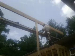 Carpenter setting a ridge beam over a new addition frame — Ice Dam Removal by Roofing Brothers in Alton